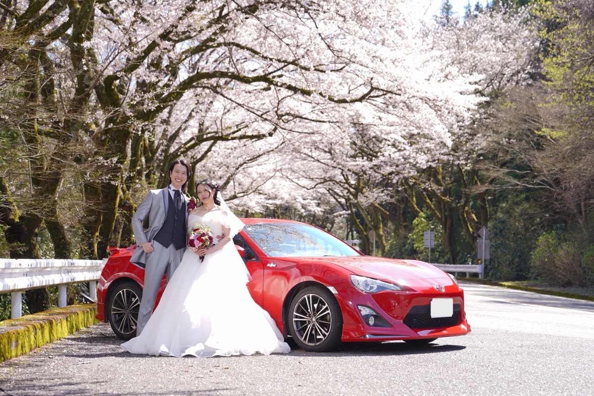 桜並木と赤いスポーツカーを背景にした撮影スポット